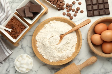 Photo of Flat lay composition with flour, chocolate and other ingredients for making dough on white marble table