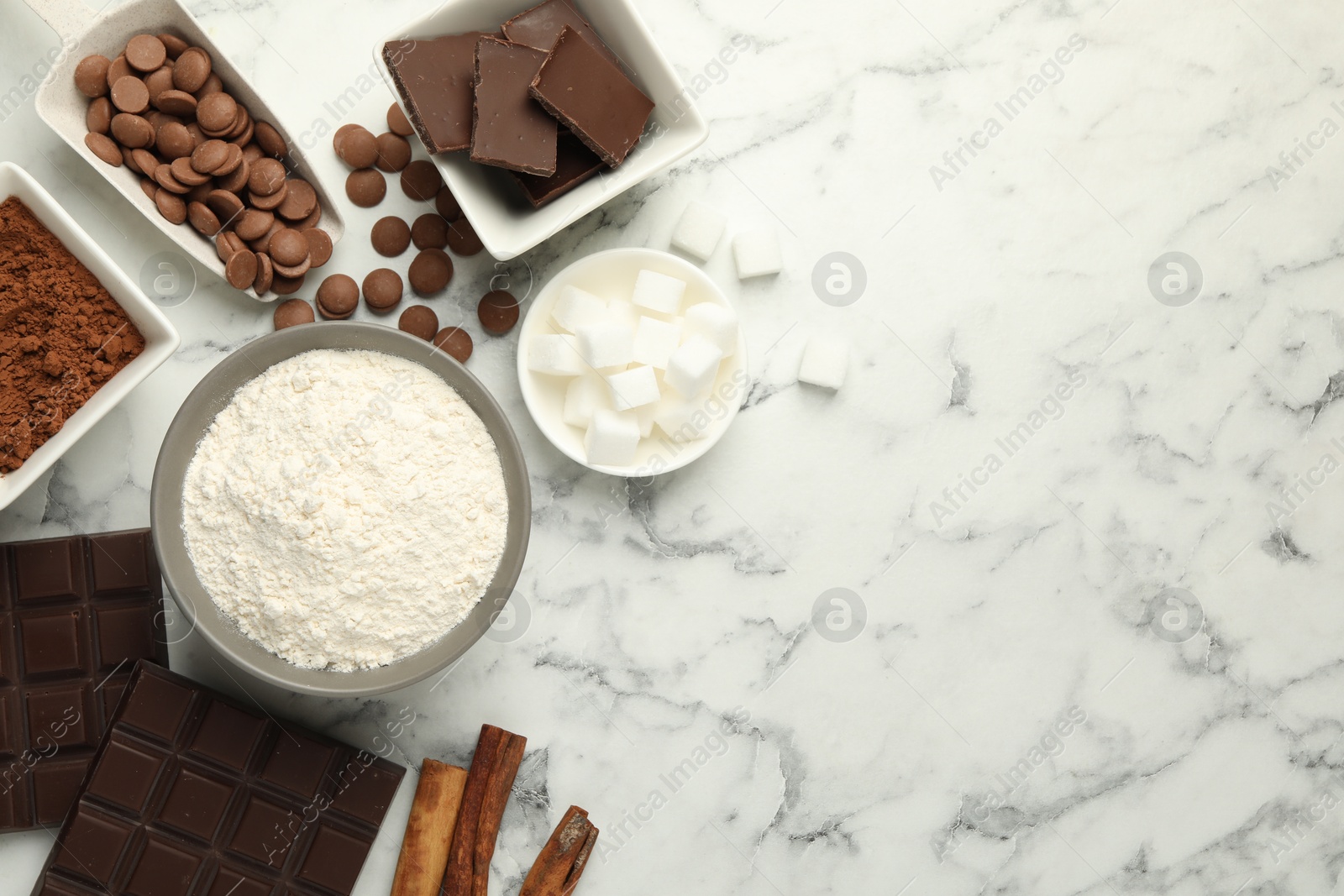 Photo of Flat lay composition with flour, chocolate and other ingredients for making dough on white marble table. Space for text