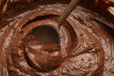 Photo of Chocolate dough and spoon as background, closeup