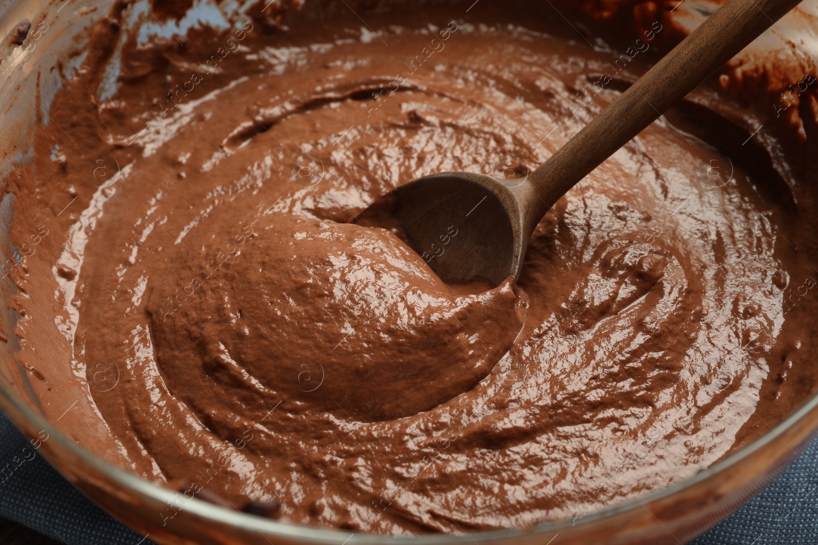 Photo of Chocolate dough and spoon in bowl, closeup