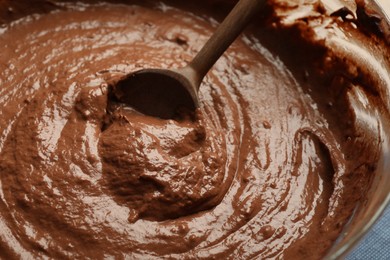 Photo of Chocolate dough and spoon in bowl, closeup