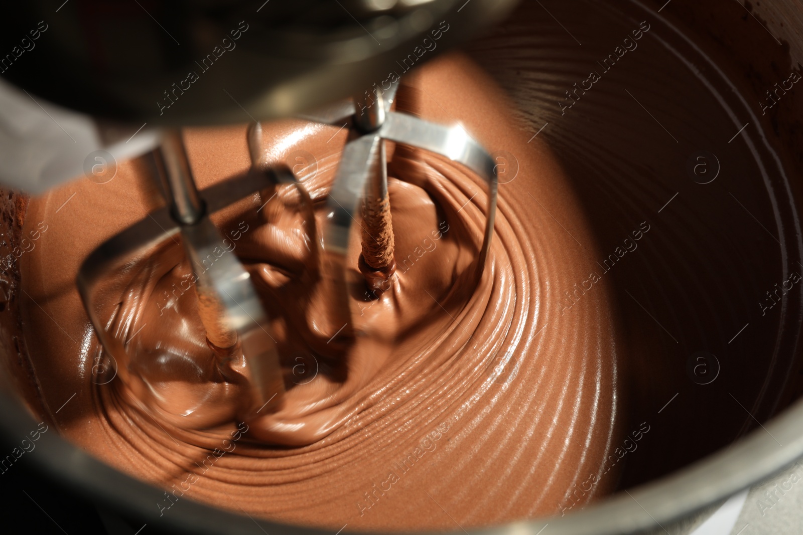 Photo of Mixing chocolate dough in bowl, closeup view