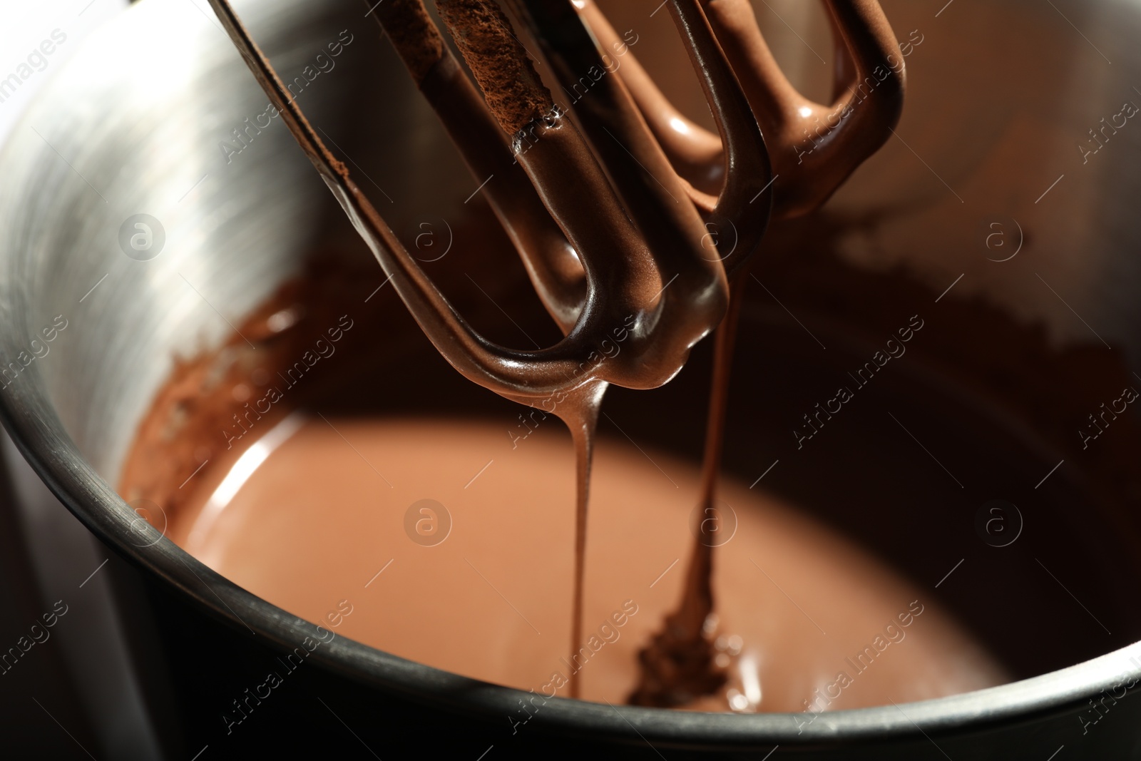 Photo of Mixing chocolate dough in bowl, closeup view