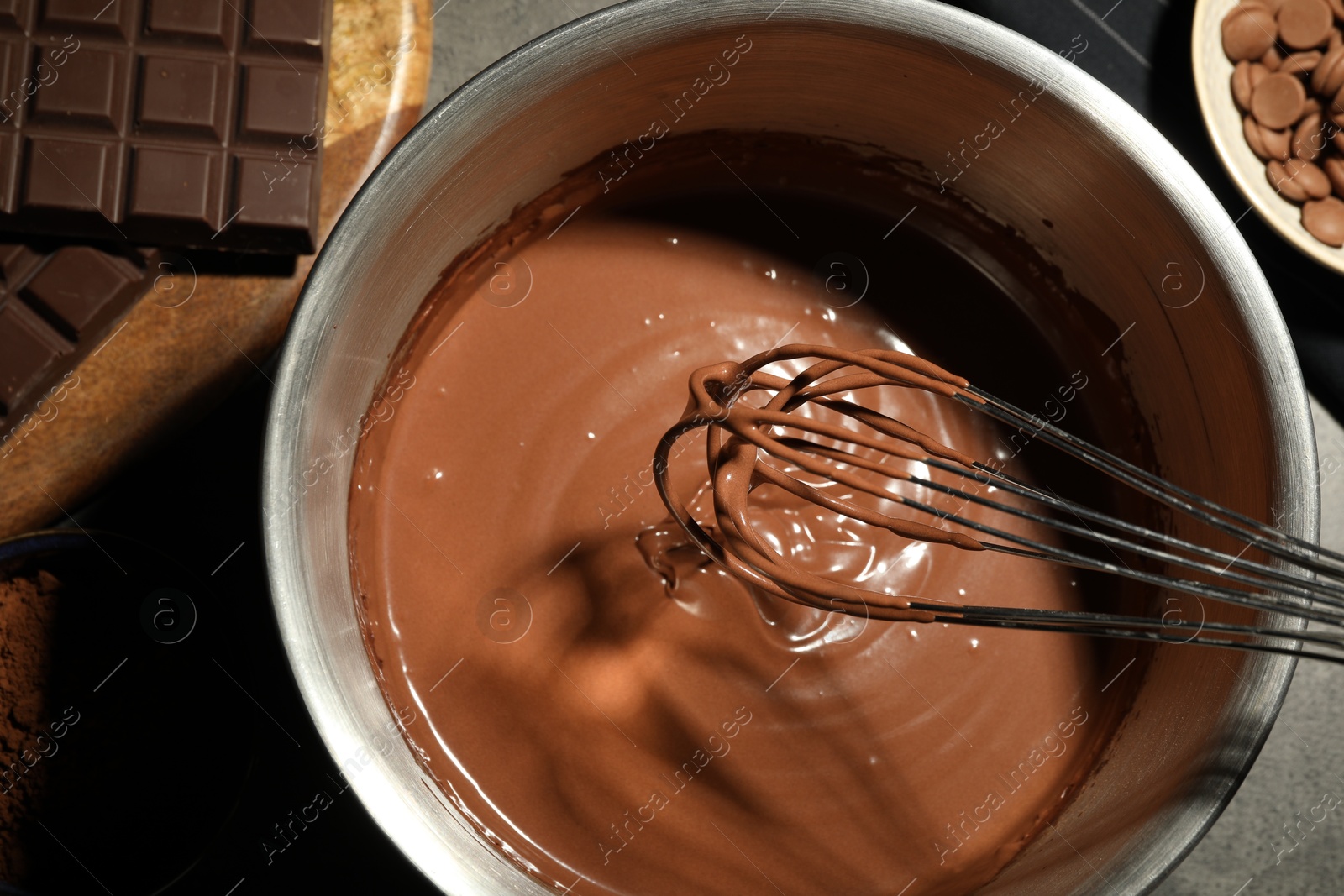 Photo of Chocolate dough in bowl and ingredients on grey table, top view