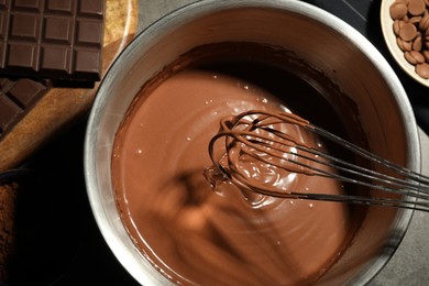 Photo of Chocolate dough in bowl and ingredients on grey table, top view