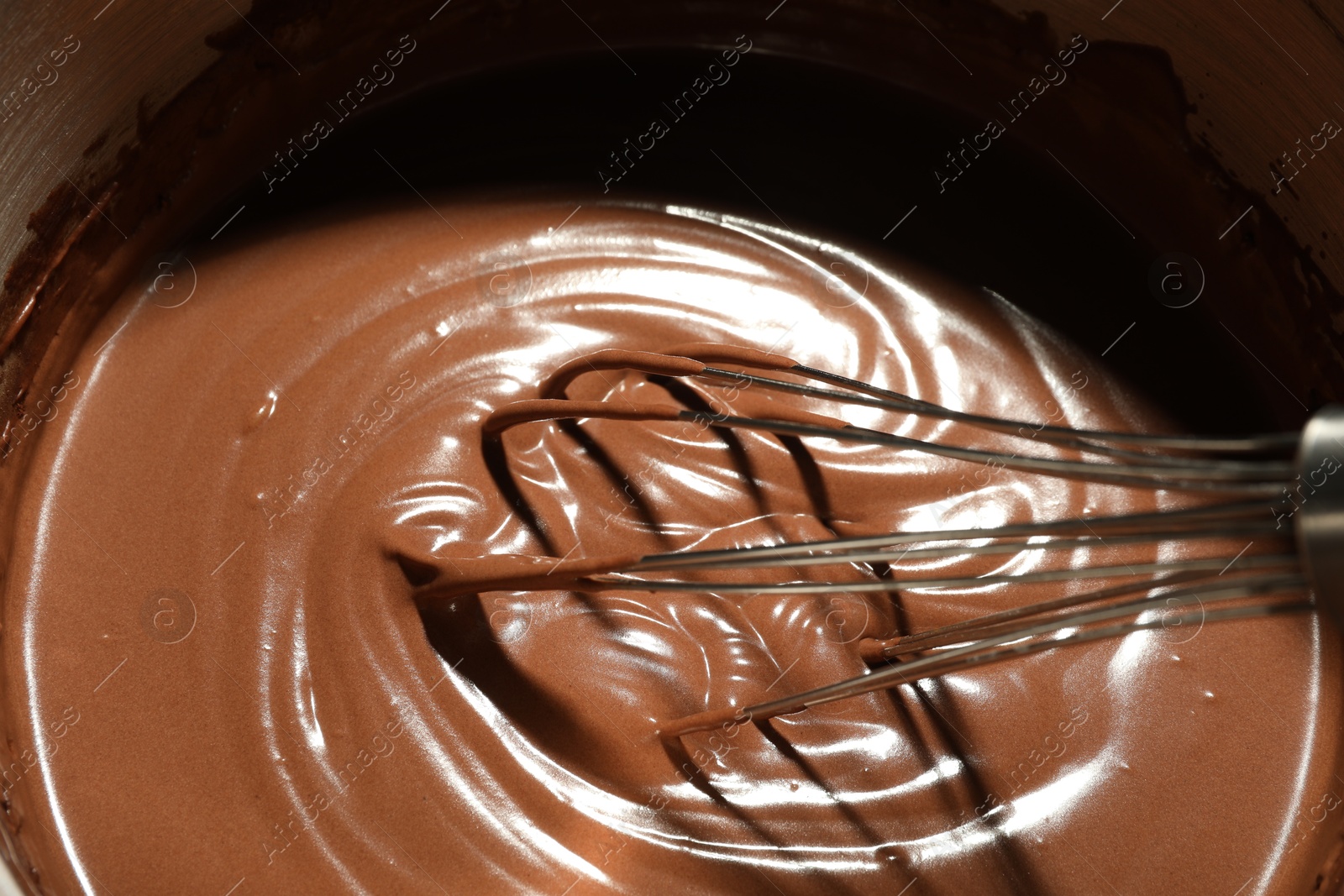 Photo of Mixing chocolate dough with whisk, closeup view