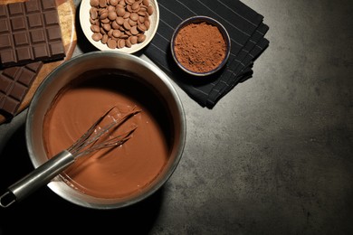 Photo of Chocolate dough in bowl and ingredients on grey table, flat lay. Space for text