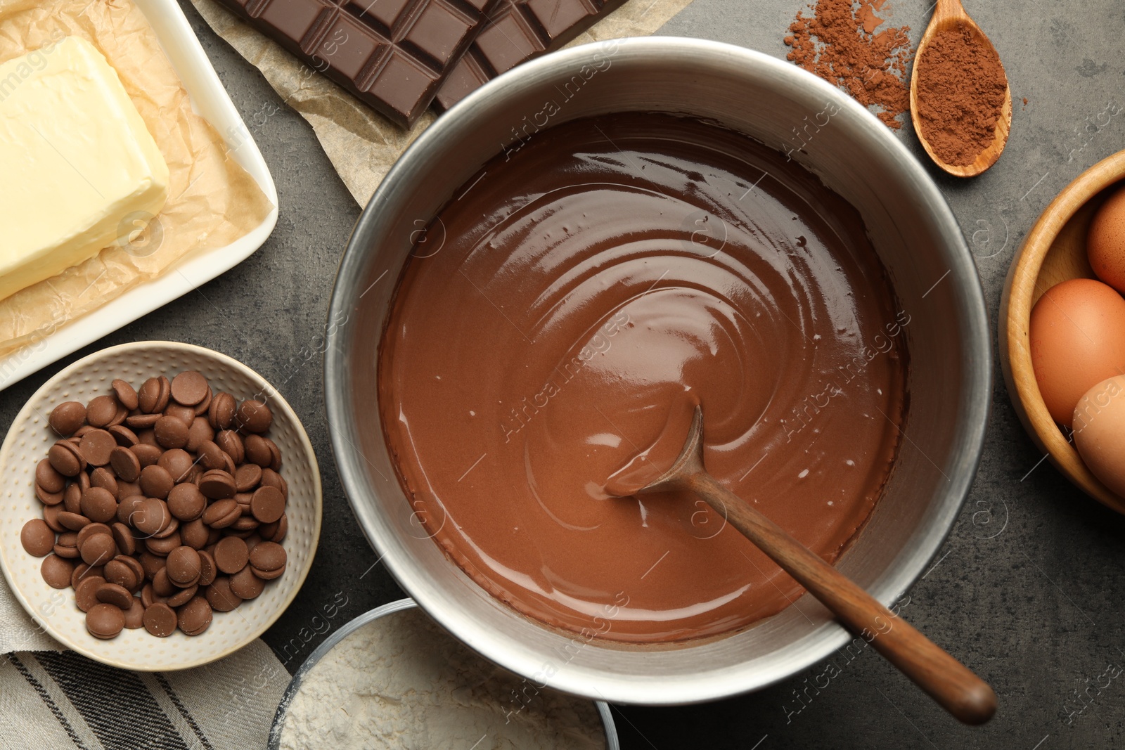 Photo of Chocolate dough in bowl and ingredients on grey table, flat lay