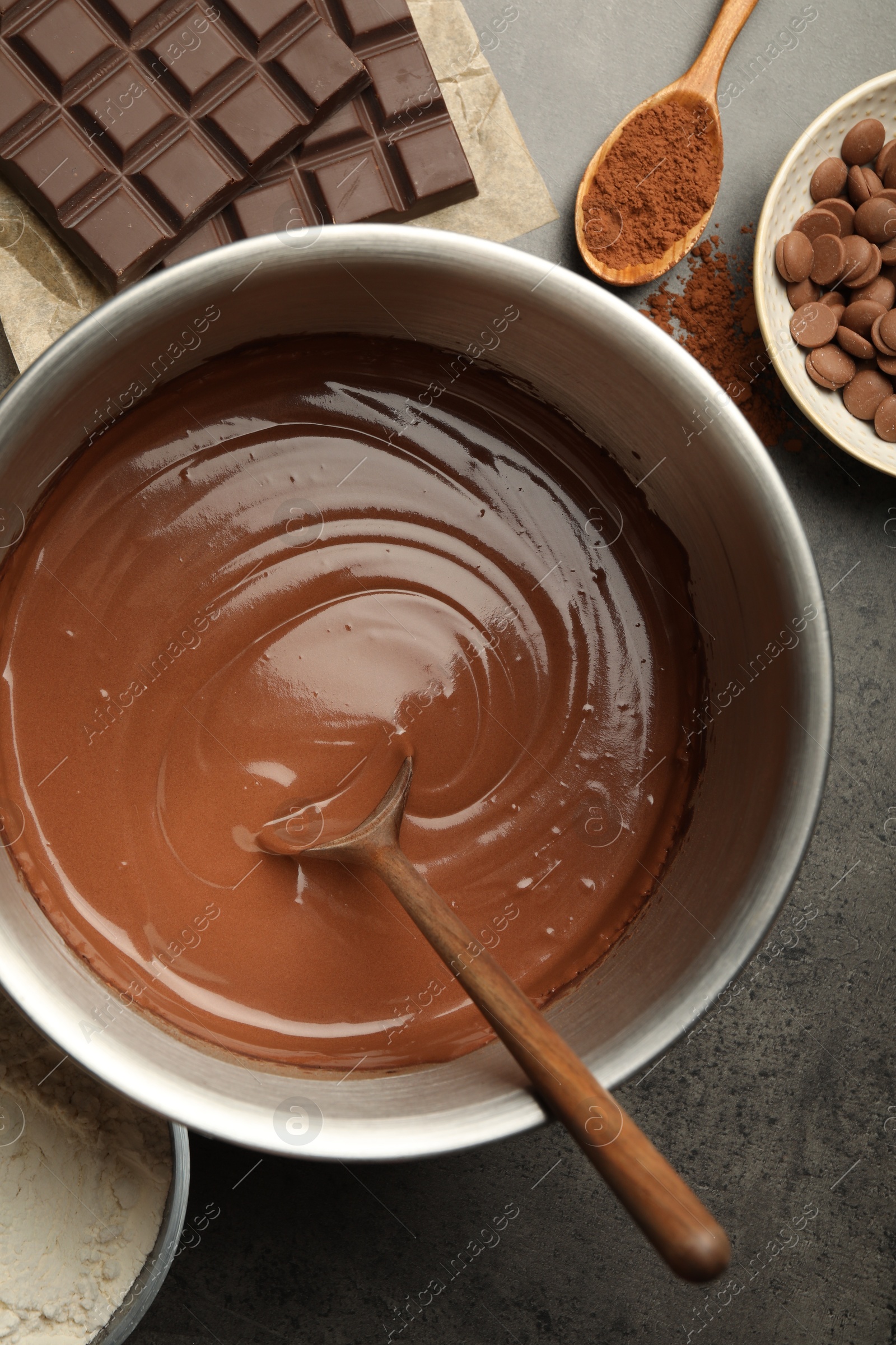 Photo of Chocolate dough in bowl and ingredients on grey table, flat lay