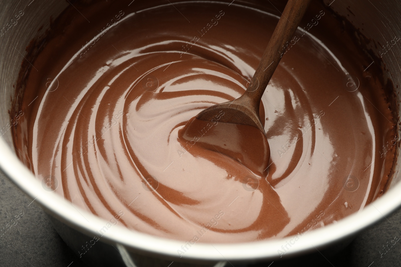 Photo of Chocolate dough and spoon in bowl, closeup