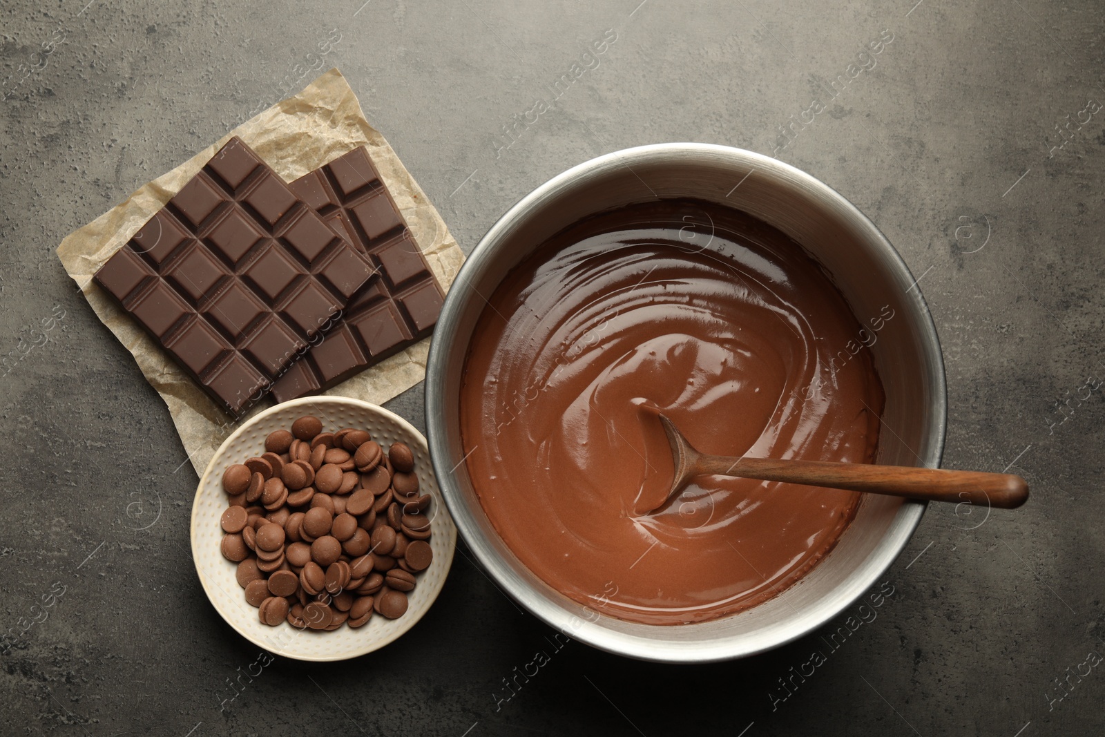 Photo of Chocolate dough in bowl and ingredients on grey table, flat lay