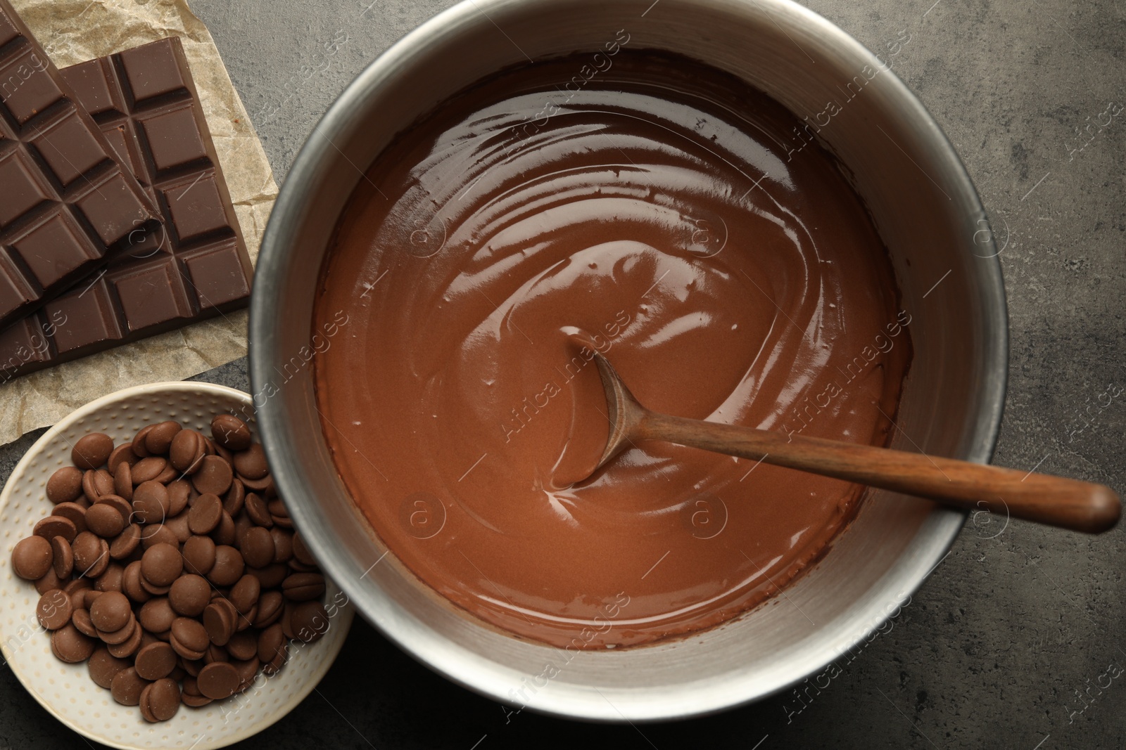 Photo of Chocolate dough in bowl and ingredients on grey table, flat lay