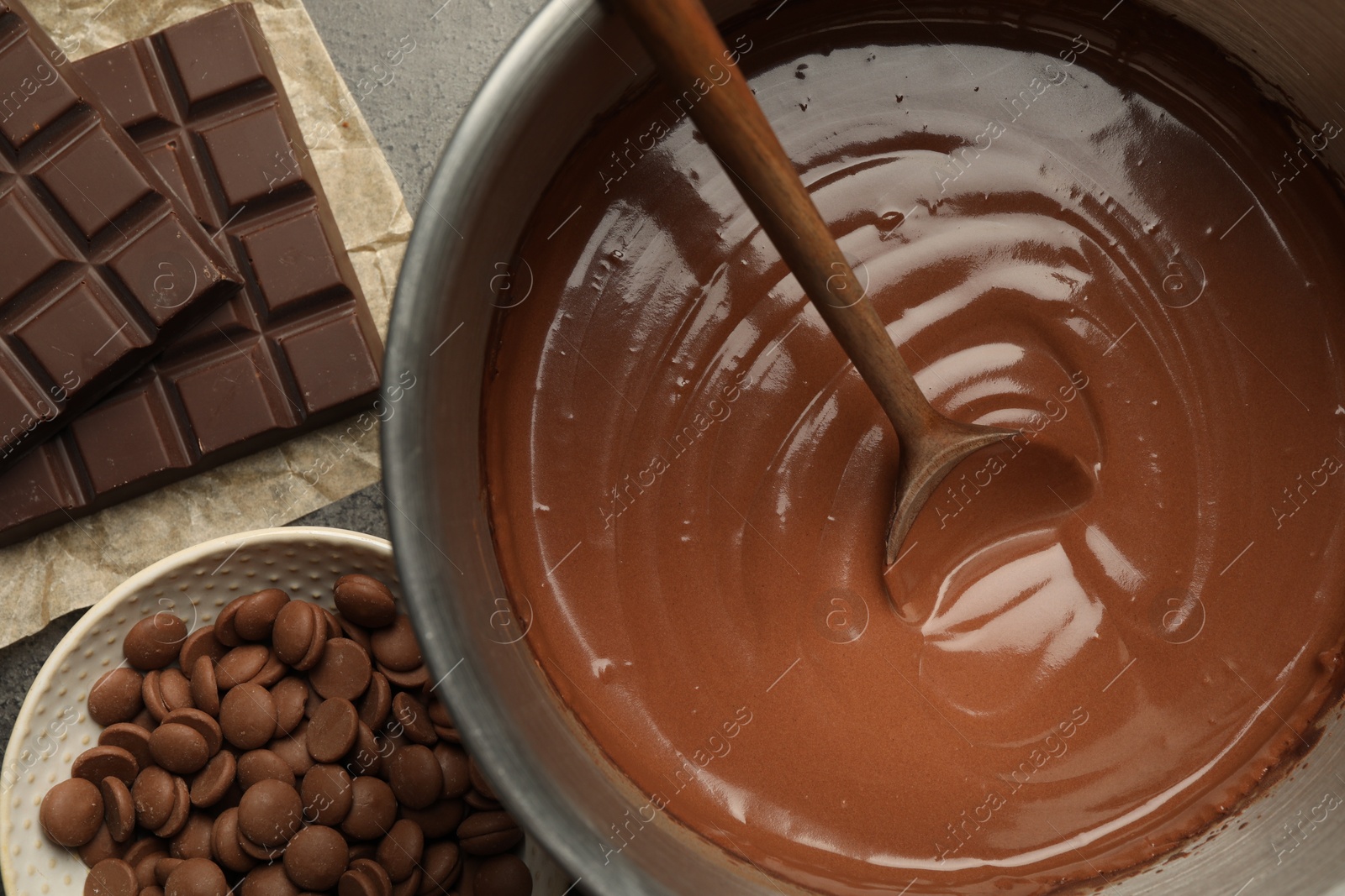 Photo of Chocolate dough in bowl and ingredients on grey table, flat lay