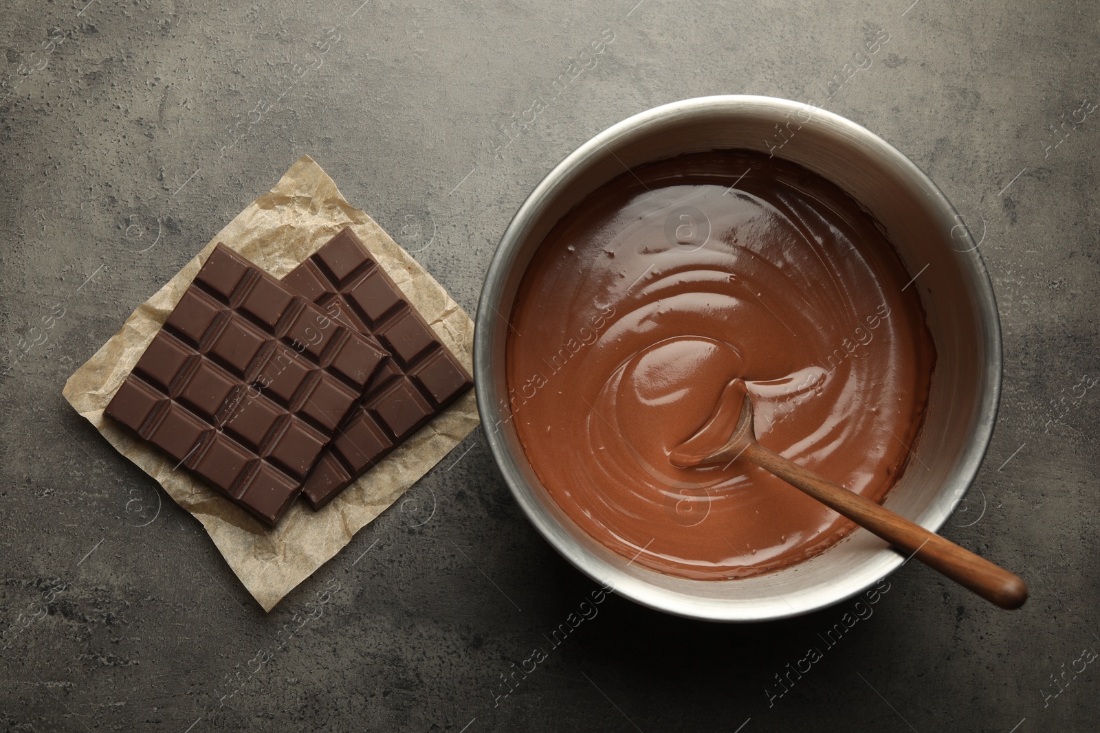 Photo of Dough in bowl and chocolate bars on grey table, flat lay