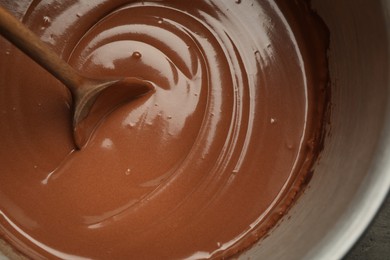 Photo of Chocolate dough and spoon in bowl, closeup