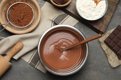 Photo of Chocolate dough in bowl and ingredients on grey table, flat lay