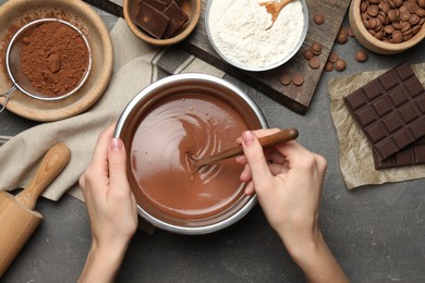 Photo of Woman making chocolate dough at grey table, top view