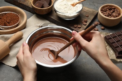 Photo of Woman making chocolate dough at grey table, closeup