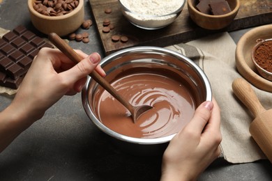 Photo of Woman making chocolate dough at grey table, closeup