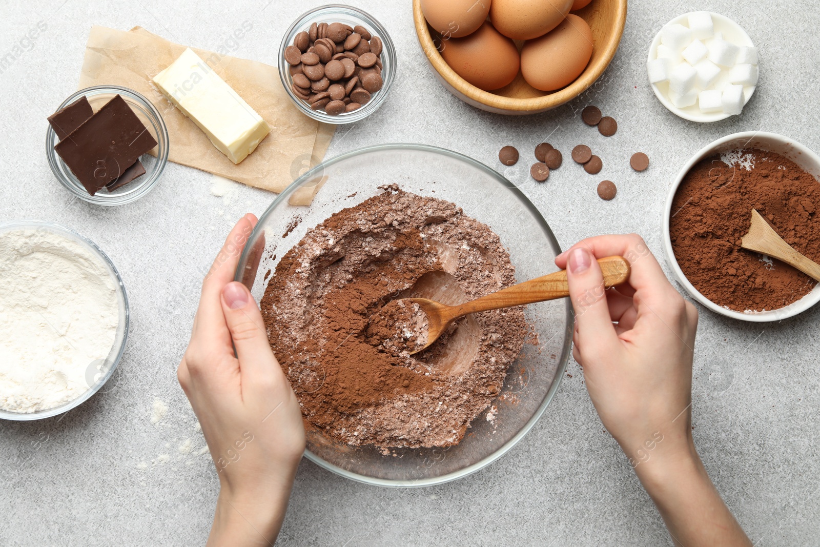 Photo of Woman making chocolate dough at light table, top view