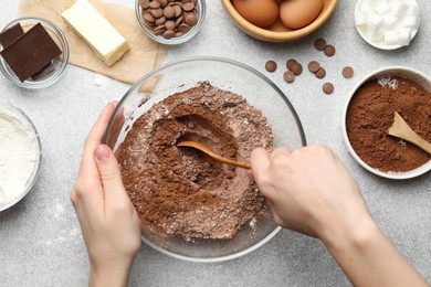 Photo of Woman making chocolate dough at light table, top view