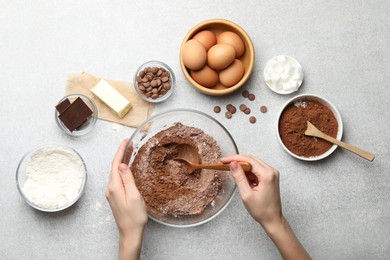 Photo of Woman making chocolate dough at light table, top view