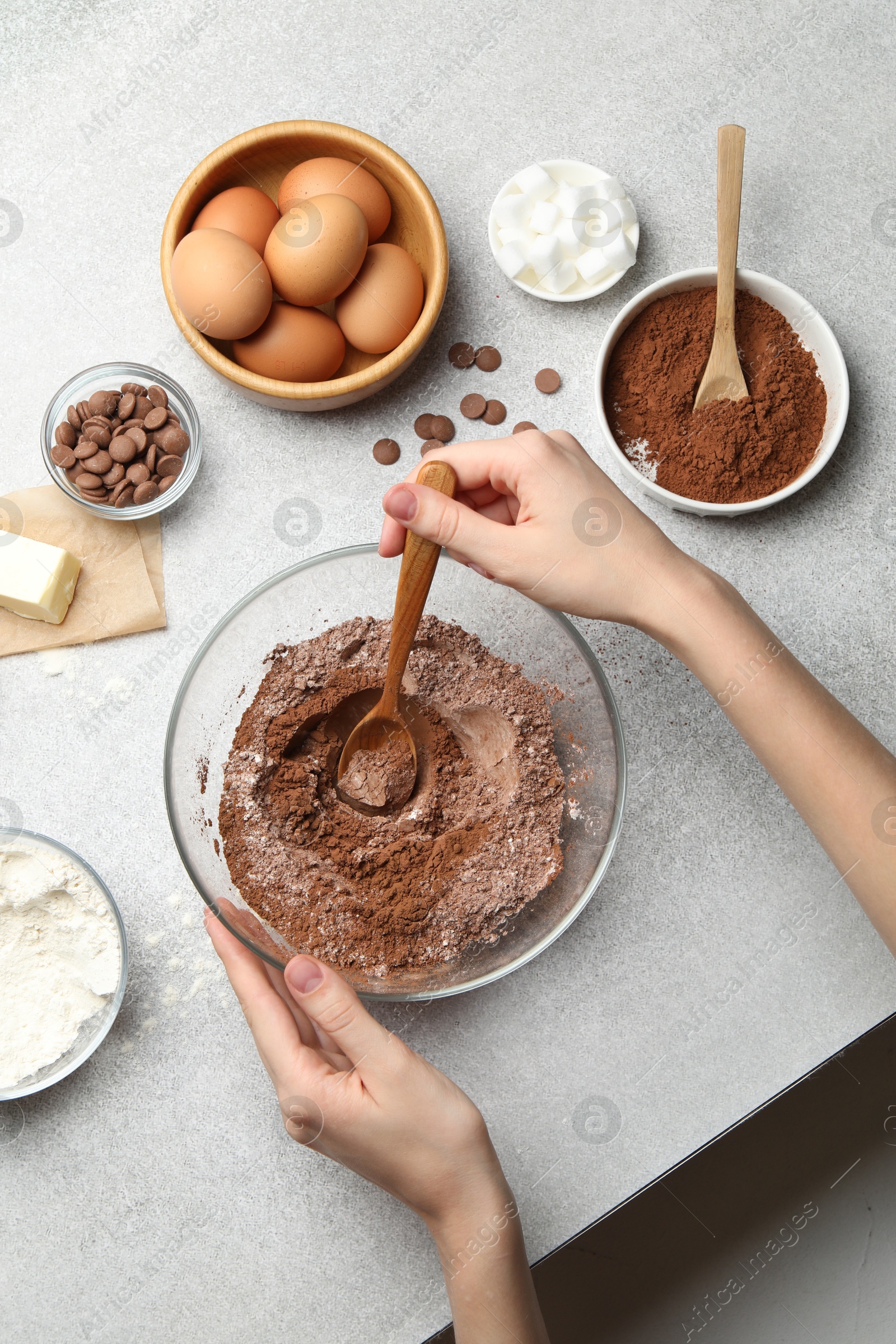 Photo of Woman making chocolate dough at light table, top view