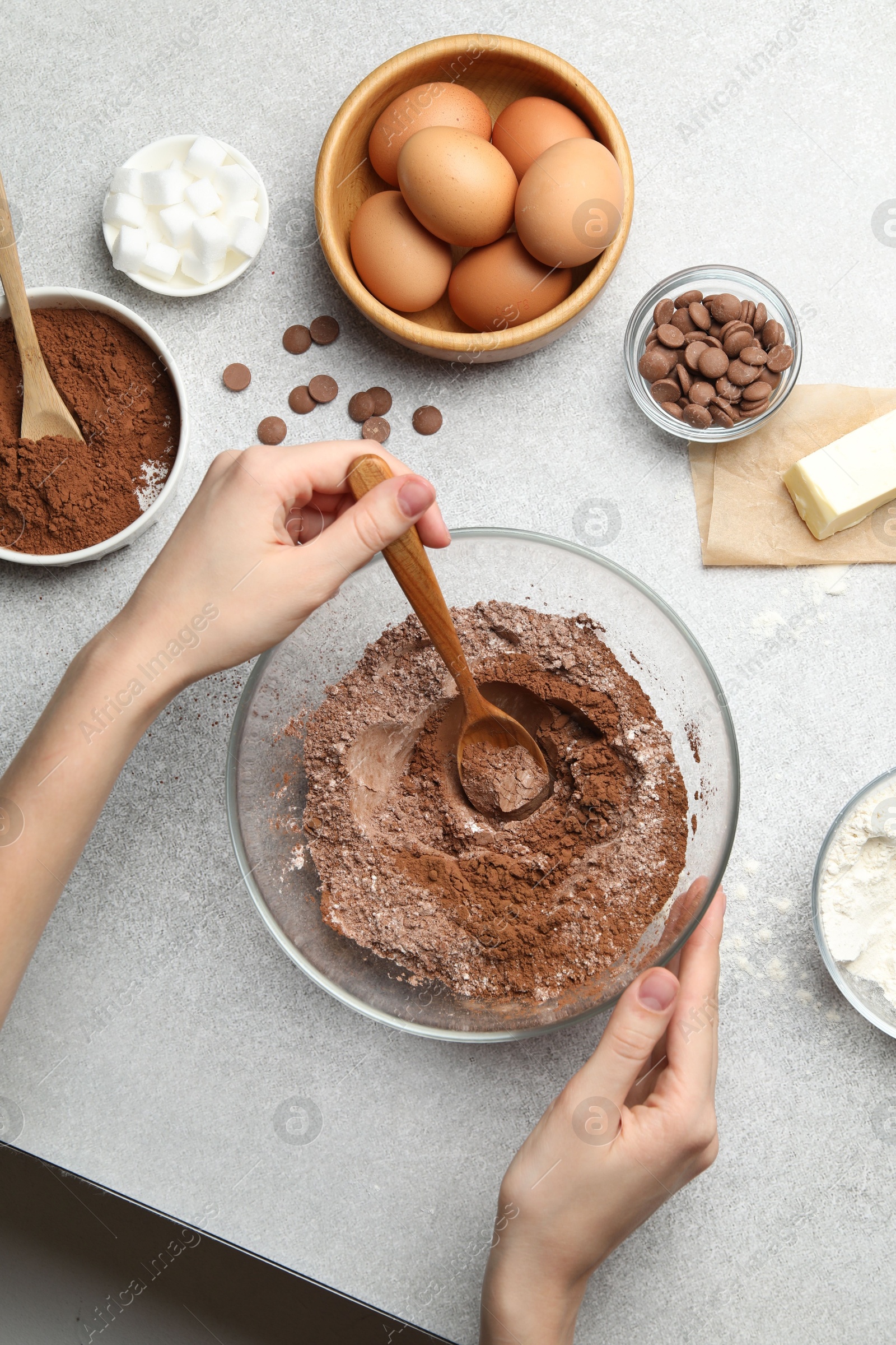 Photo of Woman making chocolate dough at light table, top view