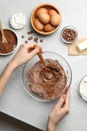 Photo of Woman making chocolate dough at light table, top view