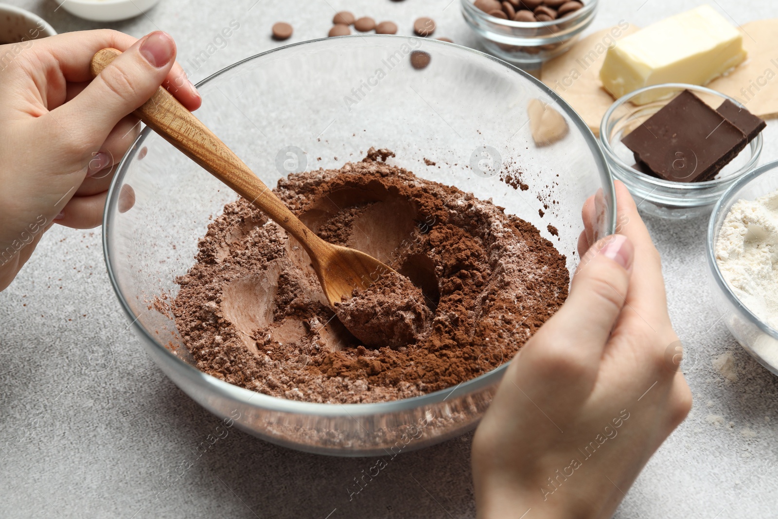 Photo of Woman making chocolate dough at light table, closeup