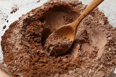 Photo of Making chocolate dough. Mix of cocoa powder with flour and spoon in bowl, closeup