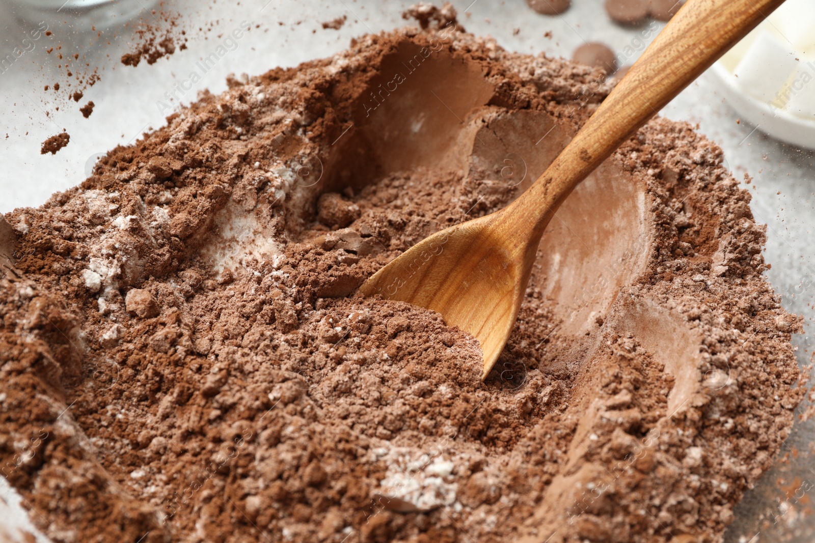 Photo of Making chocolate dough. Mix of cocoa powder with flour and spoon in bowl, closeup