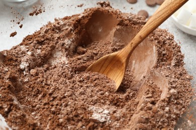 Photo of Making chocolate dough. Mix of cocoa powder with flour and spoon in bowl, closeup