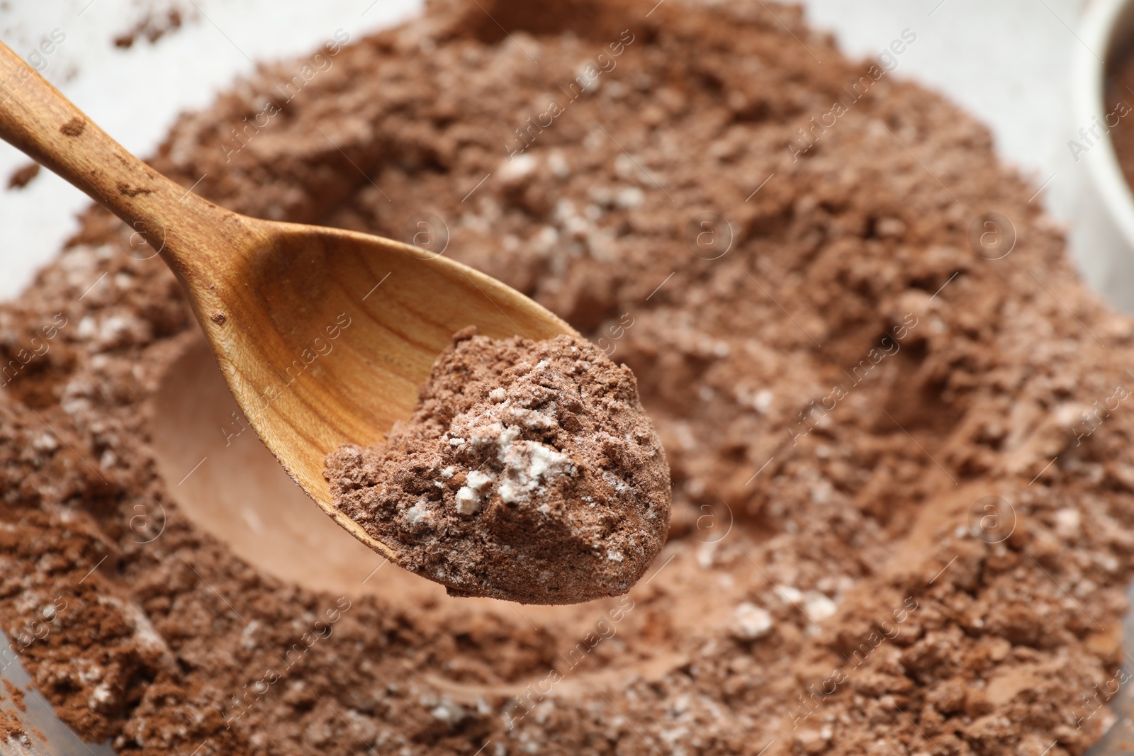 Photo of Making chocolate dough. Mix of cocoa powder with flour and spoon in bowl, closeup