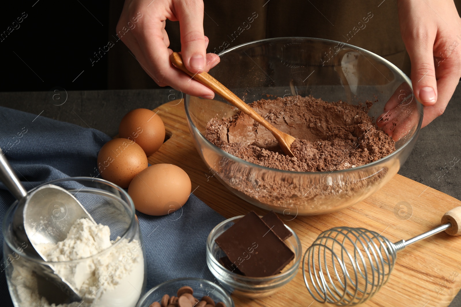 Photo of Woman making chocolate dough at grey table, closeup