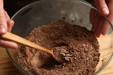 Photo of Woman making chocolate dough at table, closeup