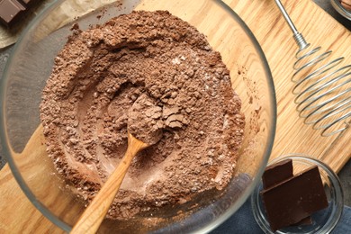 Photo of Making chocolate dough. Mix of cocoa powder with flour and spoon in bowl on table, top view