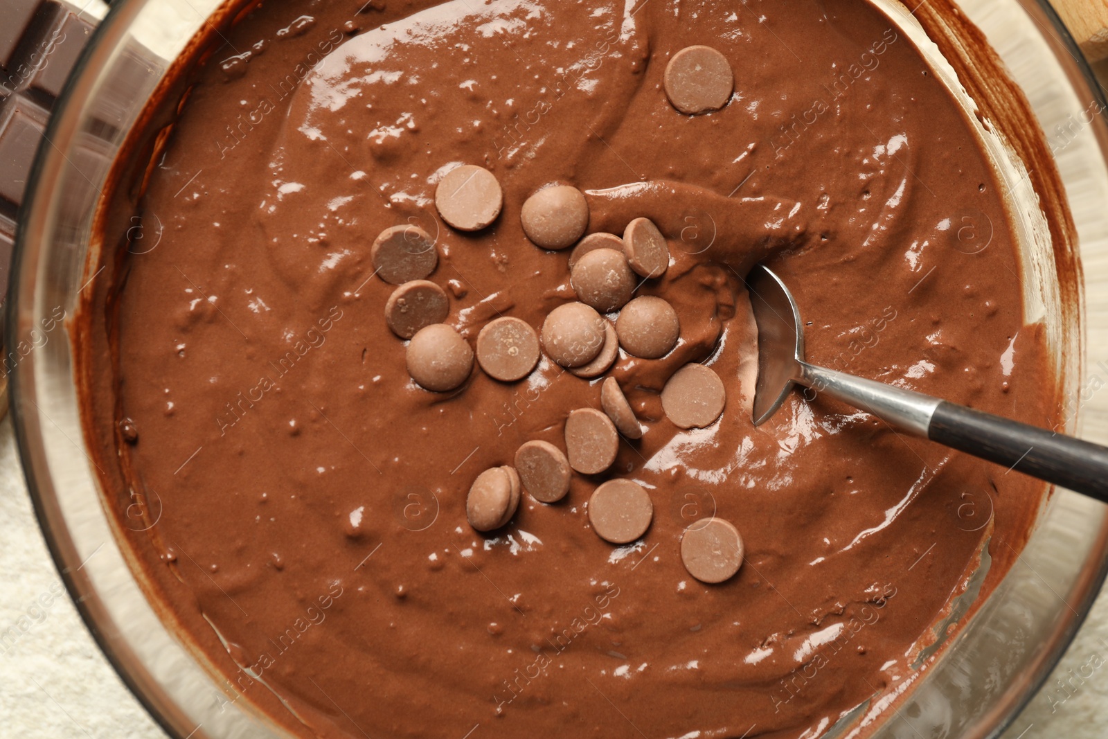 Photo of Melting chocolate chips for dough in bowl on table, top view