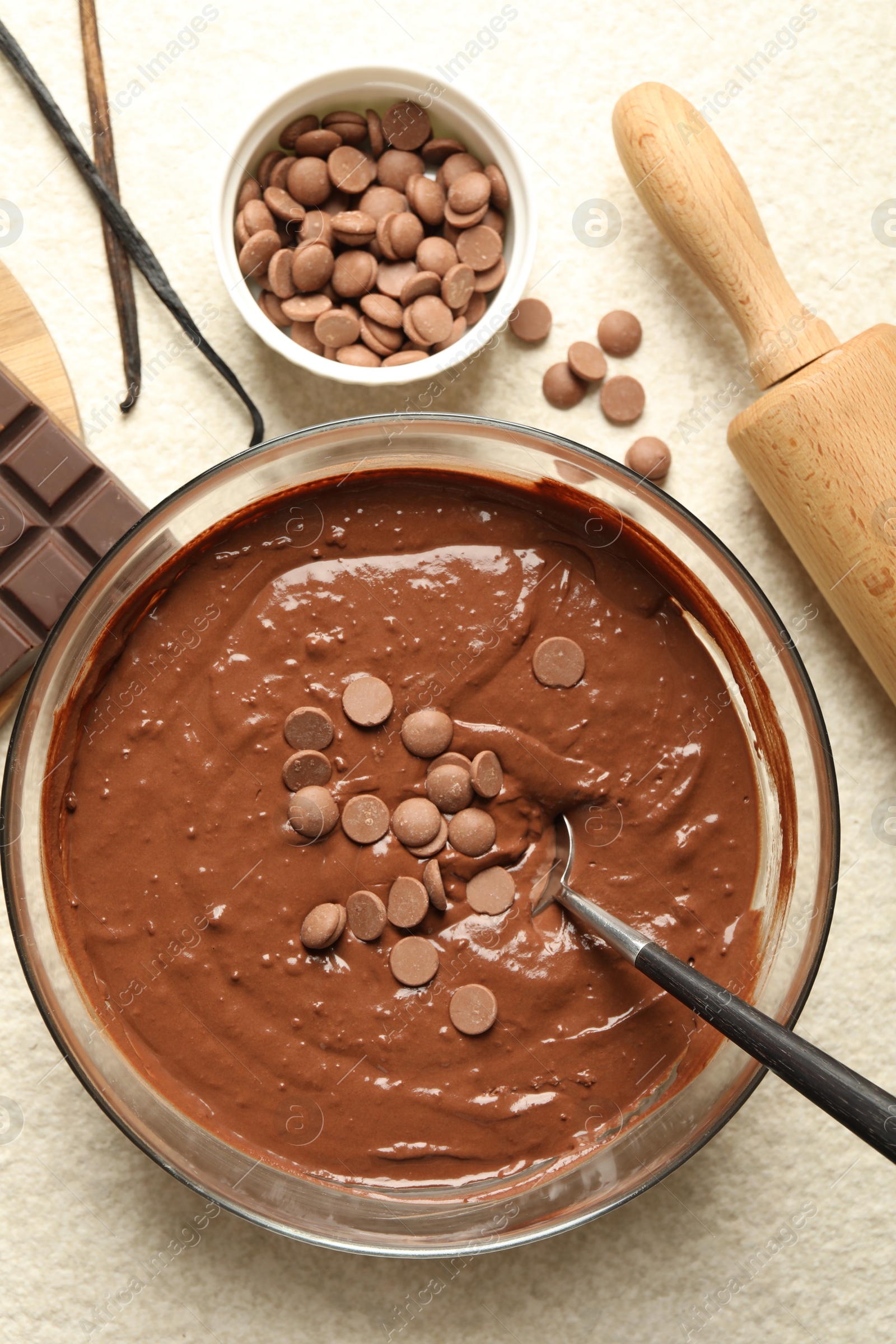 Photo of Melting chocolate chips for dough in bowl on light table, top view