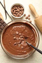 Photo of Melting chocolate chips for dough in bowl on light table, top view