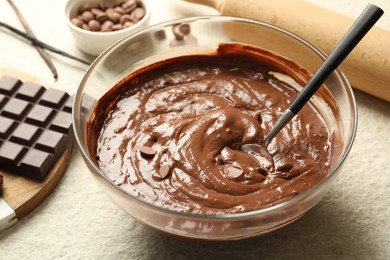 Photo of Melting chocolate chips for dough in bowl on light table, closeup