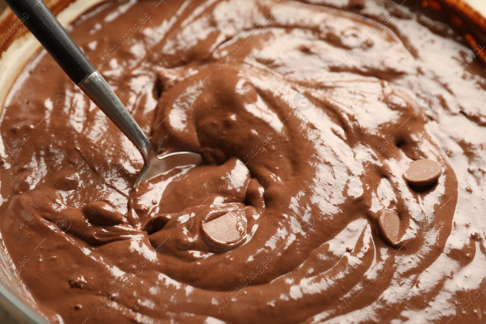 Photo of Melting chocolate chips for dough in bowl, closeup