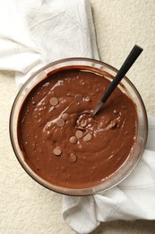 Photo of Melting chocolate chips for dough in bowl on light table, top view