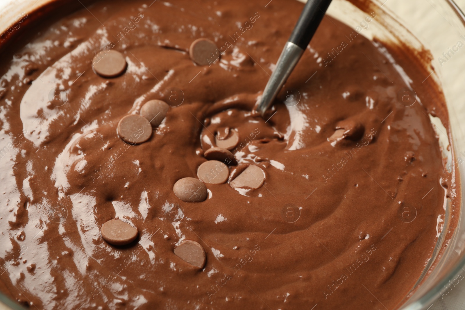 Photo of Melting chocolate chips for dough in bowl, closeup