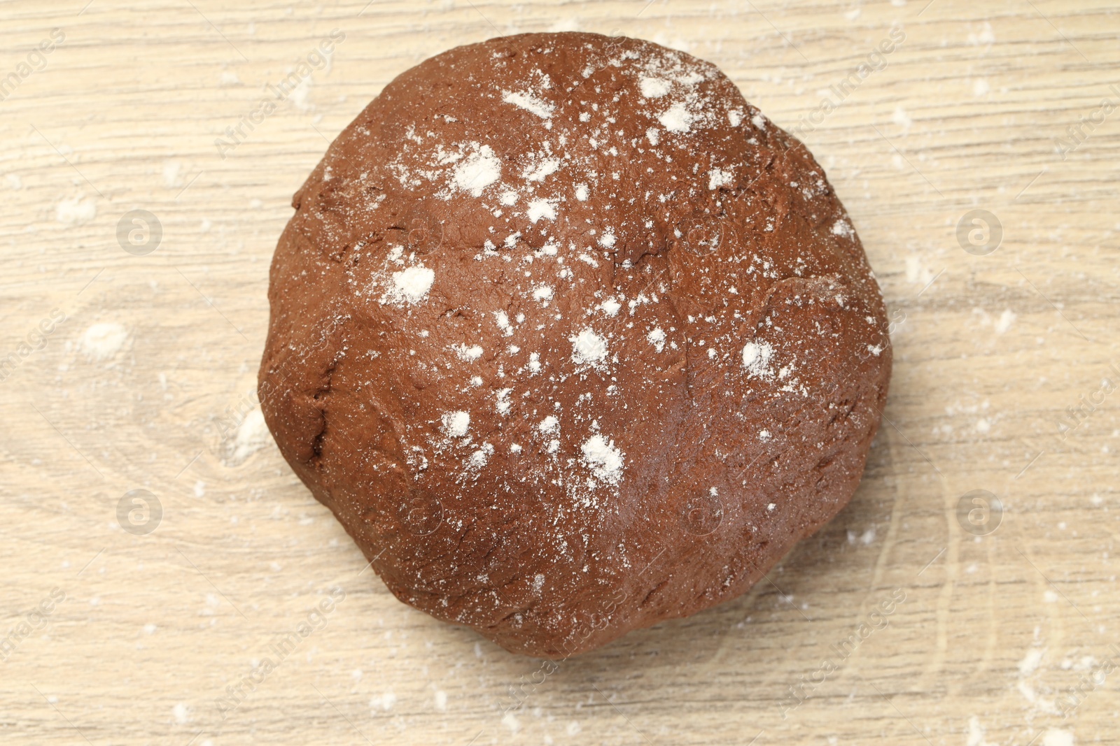 Photo of Chocolate dough on wooden table, top view