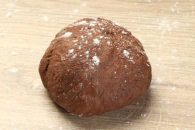 Photo of Chocolate dough on wooden table, closeup view