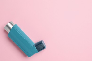 Photo of Asthma inhaler on pink background, top view. Space for text