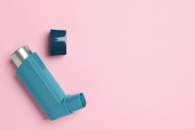 Photo of Asthma inhaler on pink background, top view. Space for text