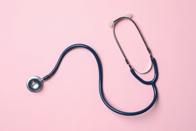 Photo of Stethoscope on pink background, top view. Medical treatment