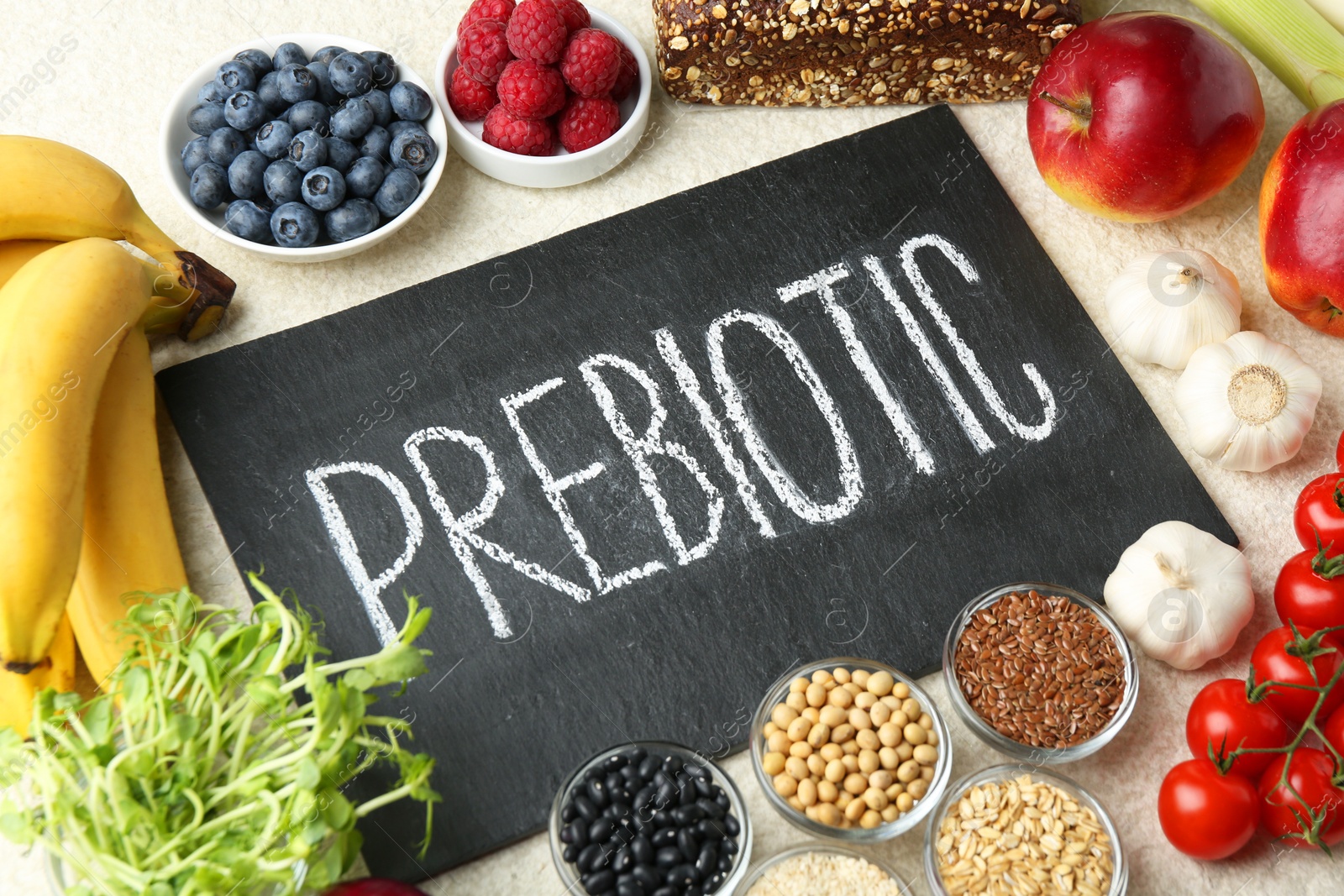 Photo of Slate board with word Prebiotic and different fresh products on grey table